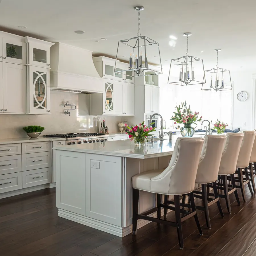 Spotless white coastal-style kitchen with a large island and pendant lights after a deep cleaning