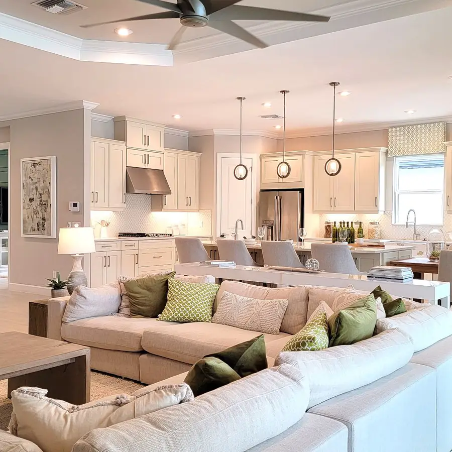 Bright open-plan Florida home with tile floors, a ceiling fan and a clean white sectional after a house cleaning